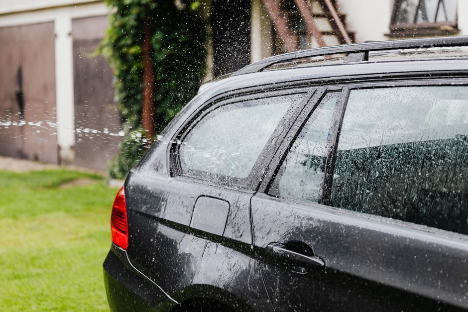 Lakýrník stříká barvu na dveře auta v lakovací kabině